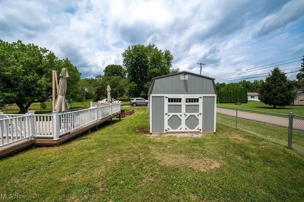 View of yard with a shed and a wooden deck