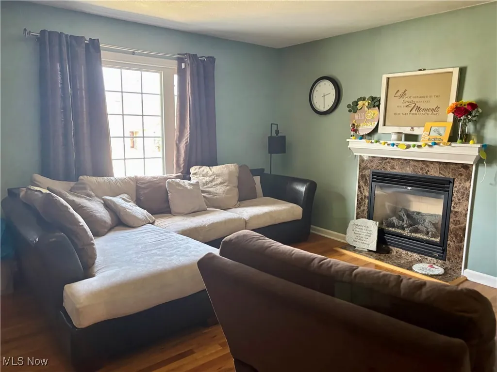 Living area with wood finished floors and a high
 end fireplace