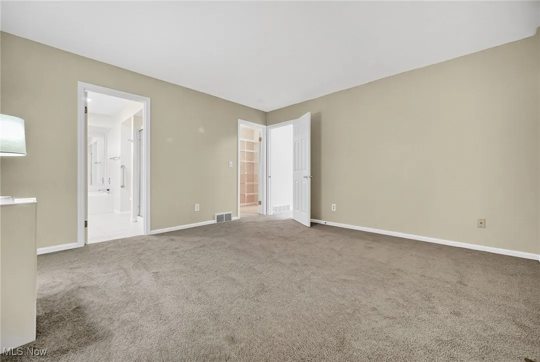 Unfurnished bedroom featuring carpet floors and ensuite bath