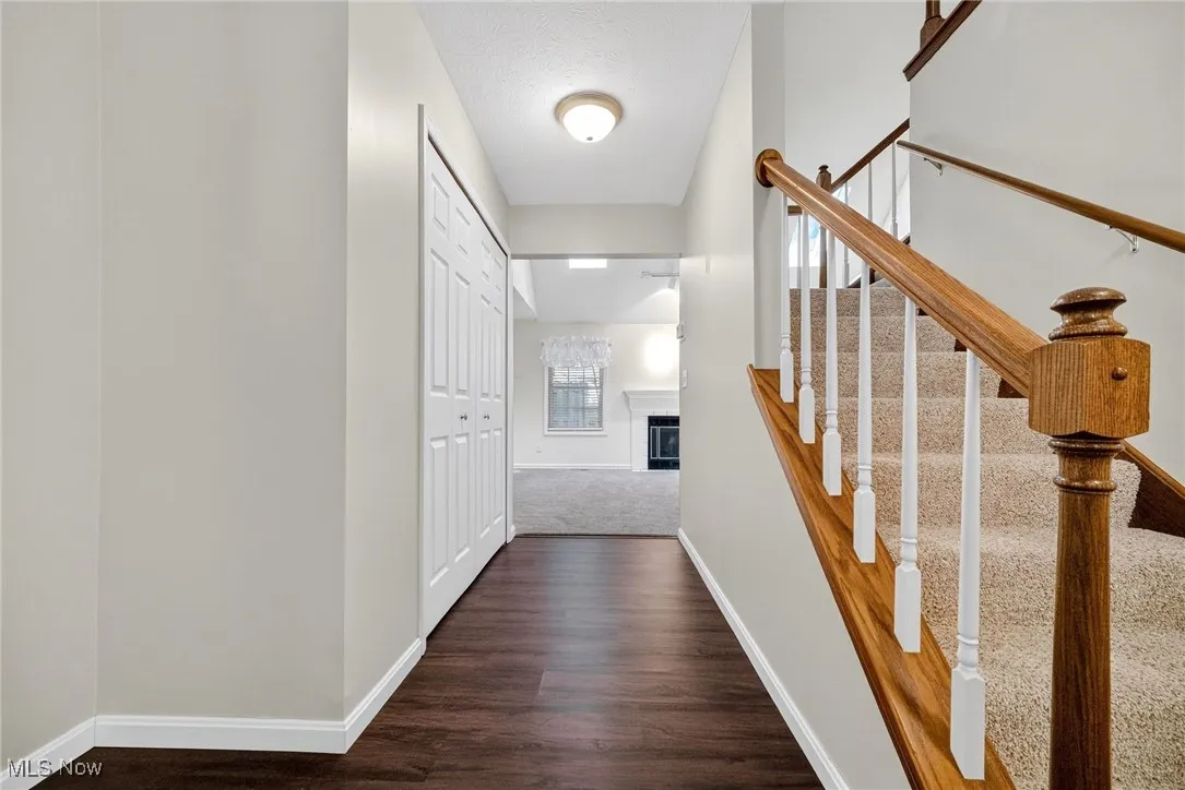 Hallway featuring dark wood-type flooring and stairway