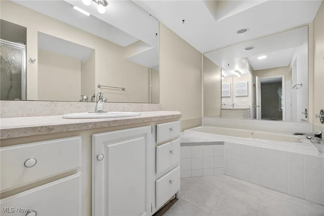 Bathroom with tile patterned floors, a bath, vanity, and an enclosed shower
