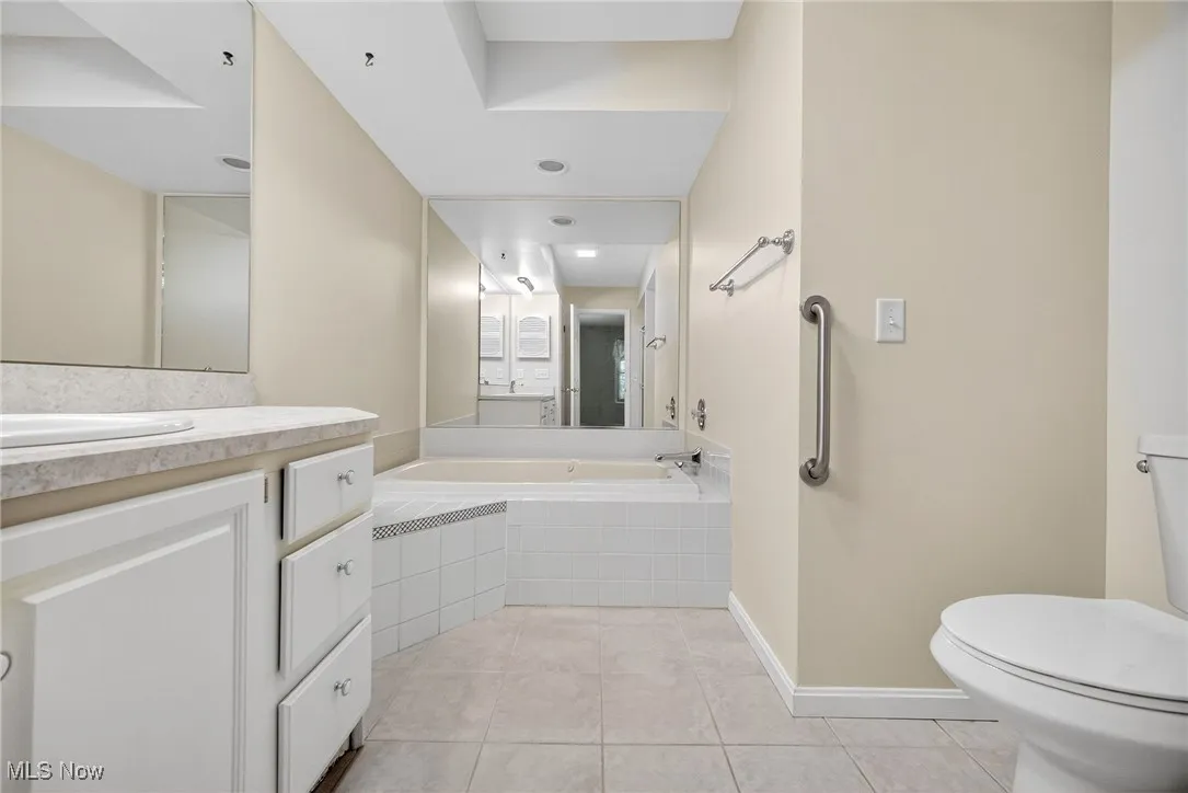 Full bath with vanity, tile patterned flooring, and a bath