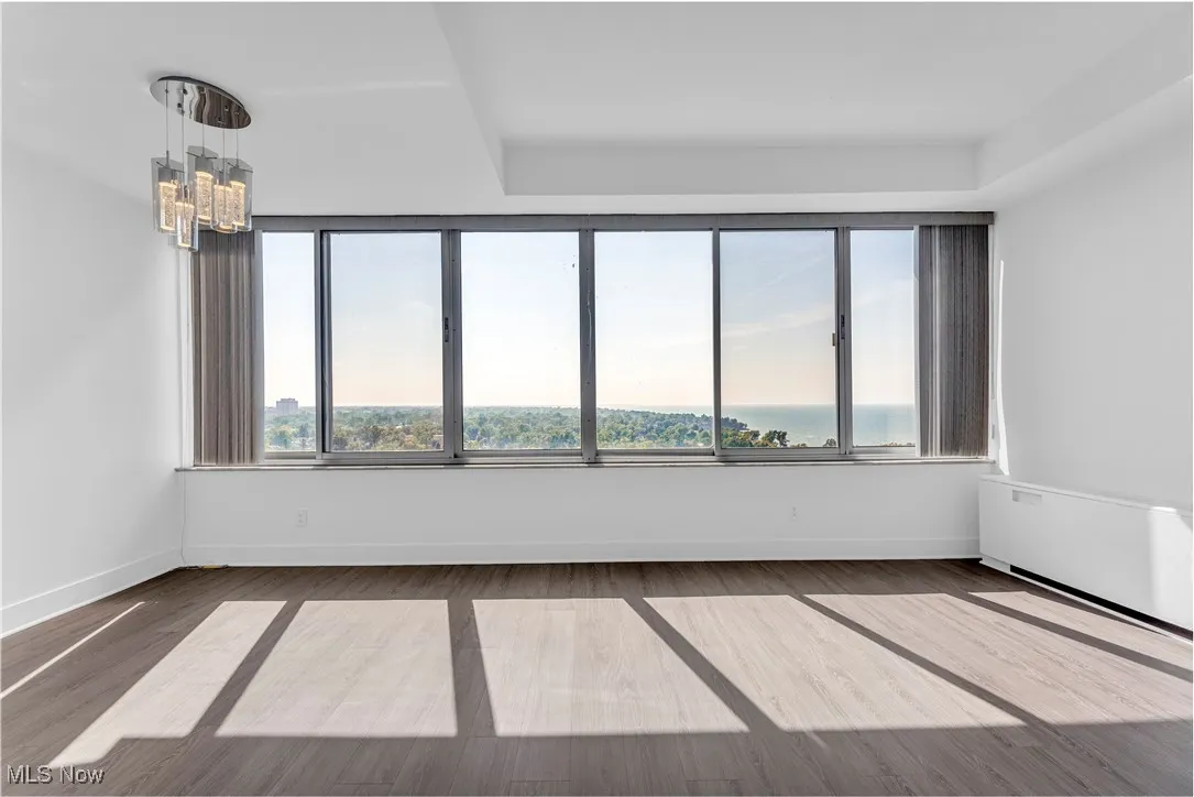 Empty room featuring a chandelier and wood finished floors