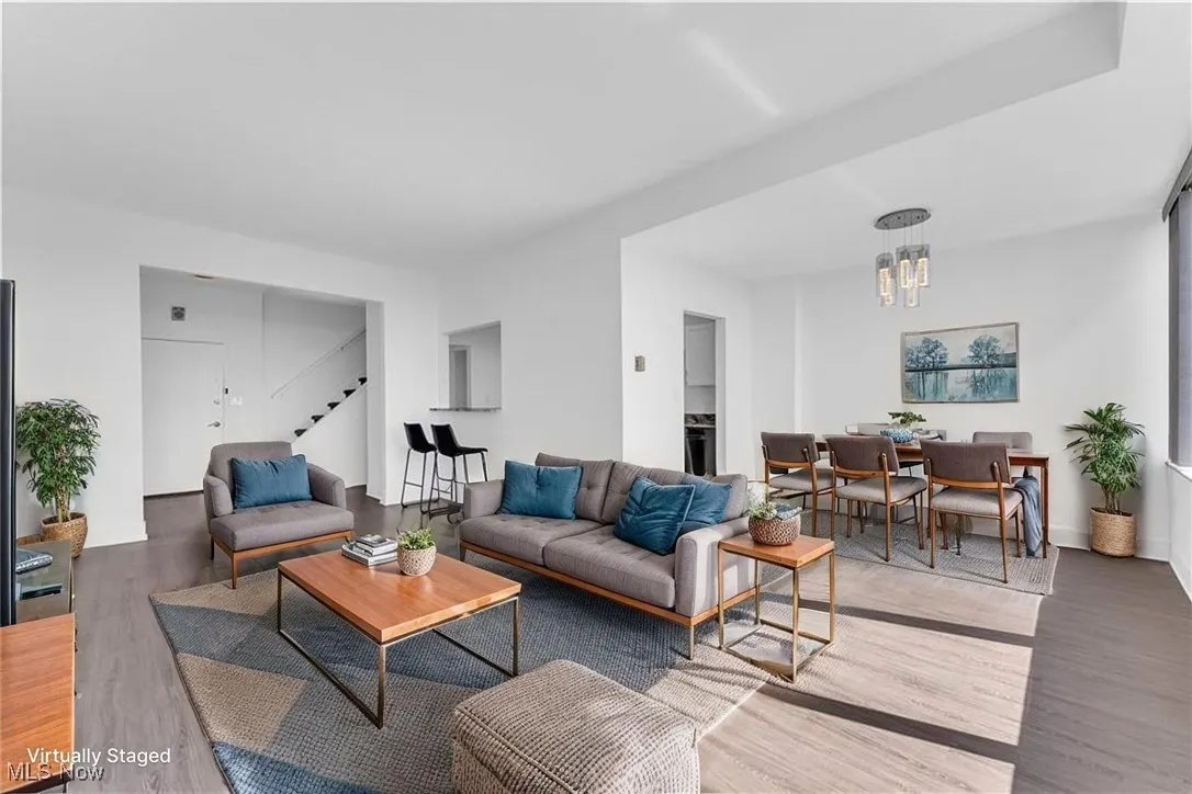 Living area featuring wood finished floors, stairs, and a chandelier
