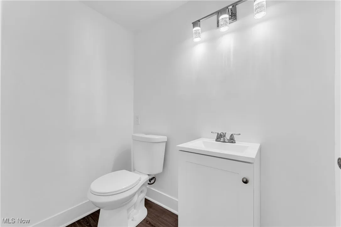 Half bath featuring wood finished floors and vanity