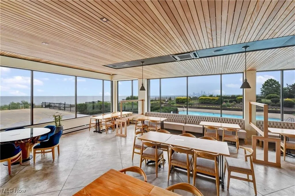 Sunroom featuring concrete floors, wooden ceiling, and baseboard heating