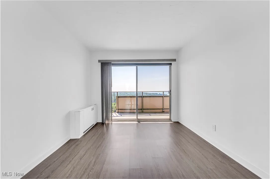 Unfurnished room with wood finished floors and baseboards