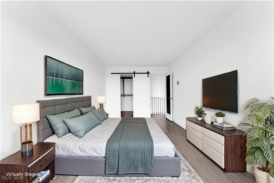 Bedroom featuring a barn door and wood finished floors