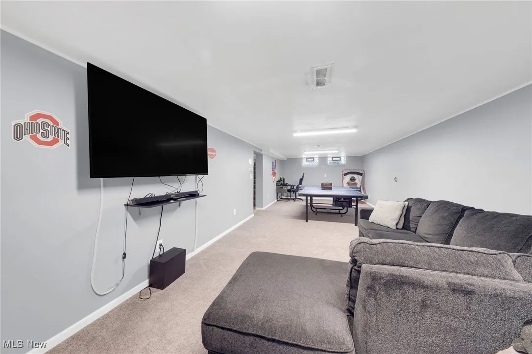 Living area featuring light colored carpet and baseboards