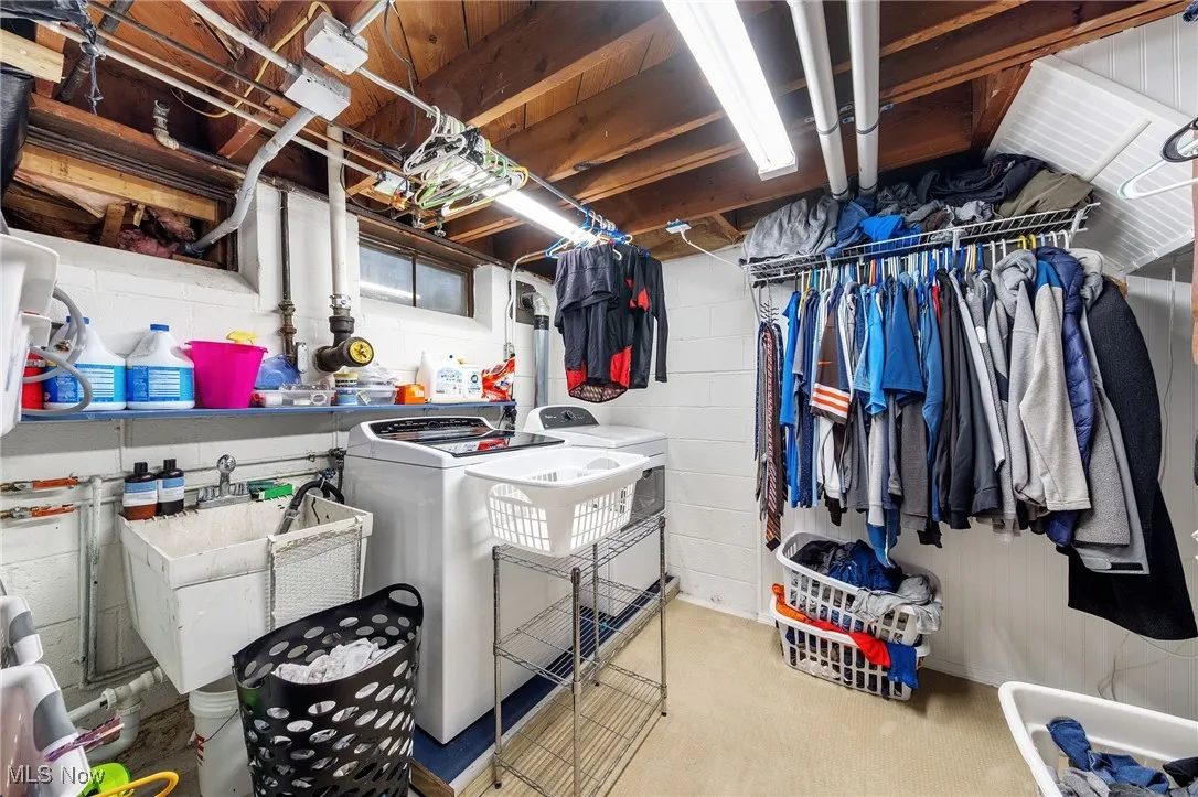 Laundry area featuring separate washer and dryer and concrete block wall
