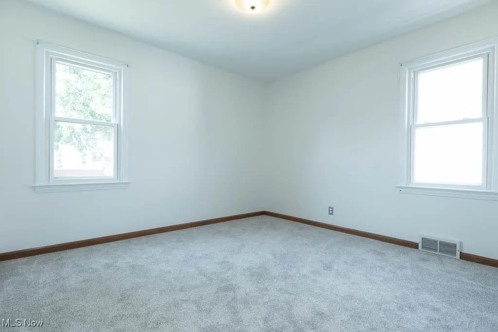 Carpeted empty room with healthy amount of natural light
