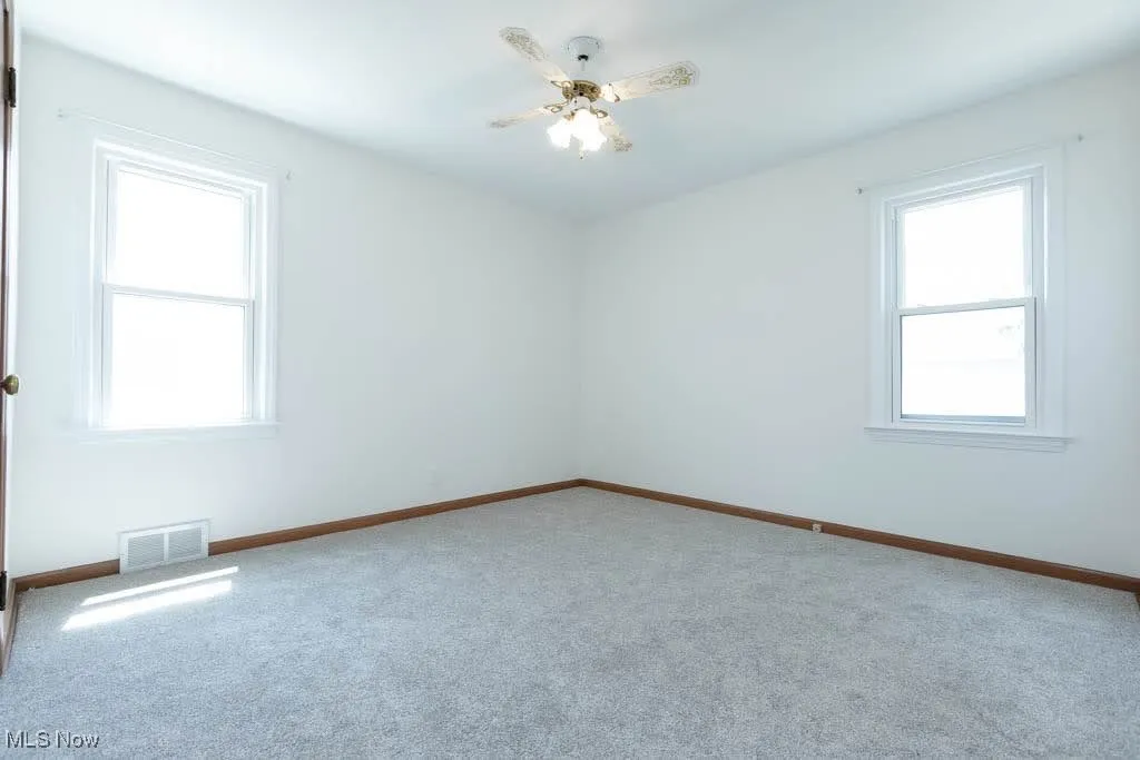 Empty room with carpet and ceiling fan