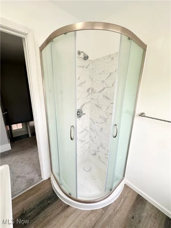 Second floor Full bathroom featuring a shower stall and wood finished floors