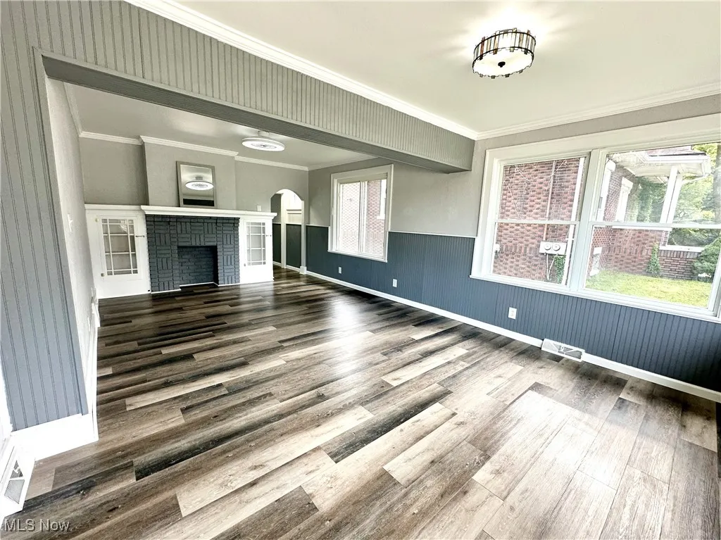 Living room featuring a decorative fireplace, and arched walkways