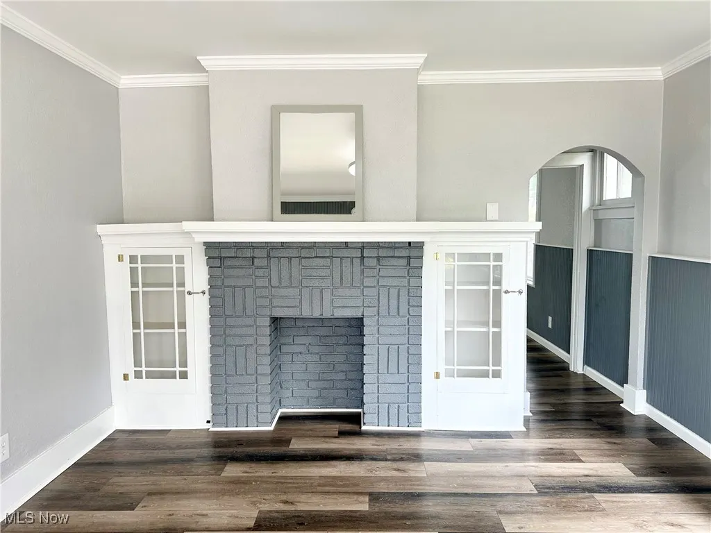 Living room featuring a decorative fireplace, and arched walkways