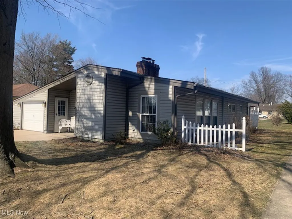 View of front facade with a garage and a chimney