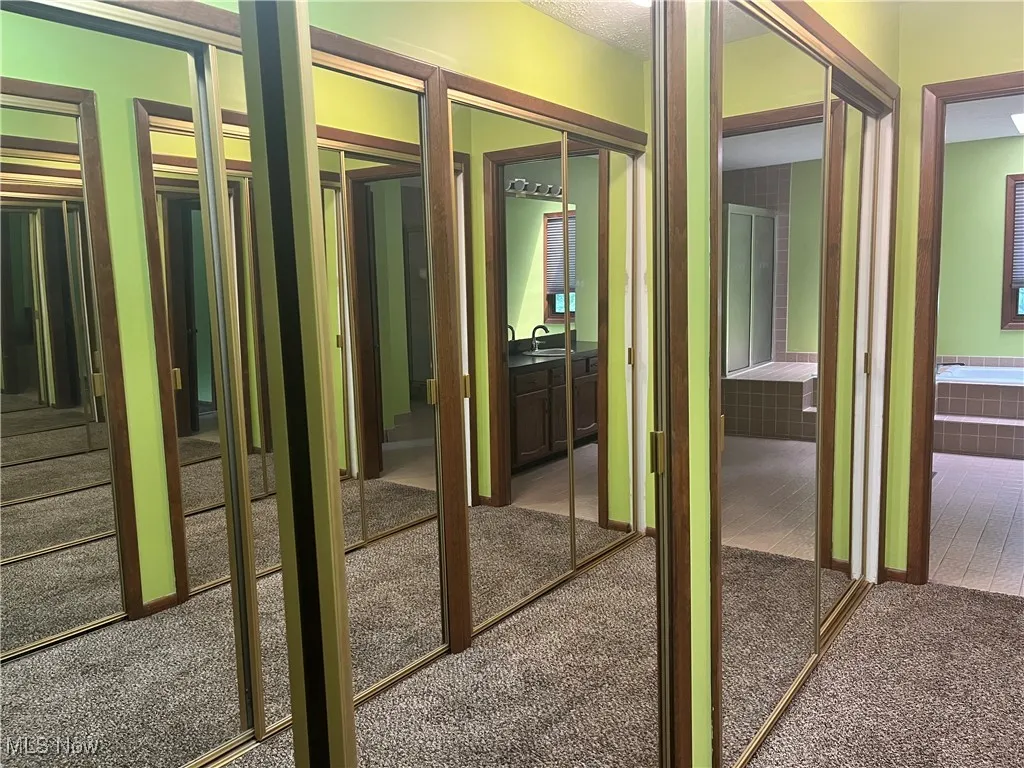 The walk thru closet consists of 6 double-doored, mirrored His and Hers Closets.  Connects the Primary Bedroom to the Primary Bath.