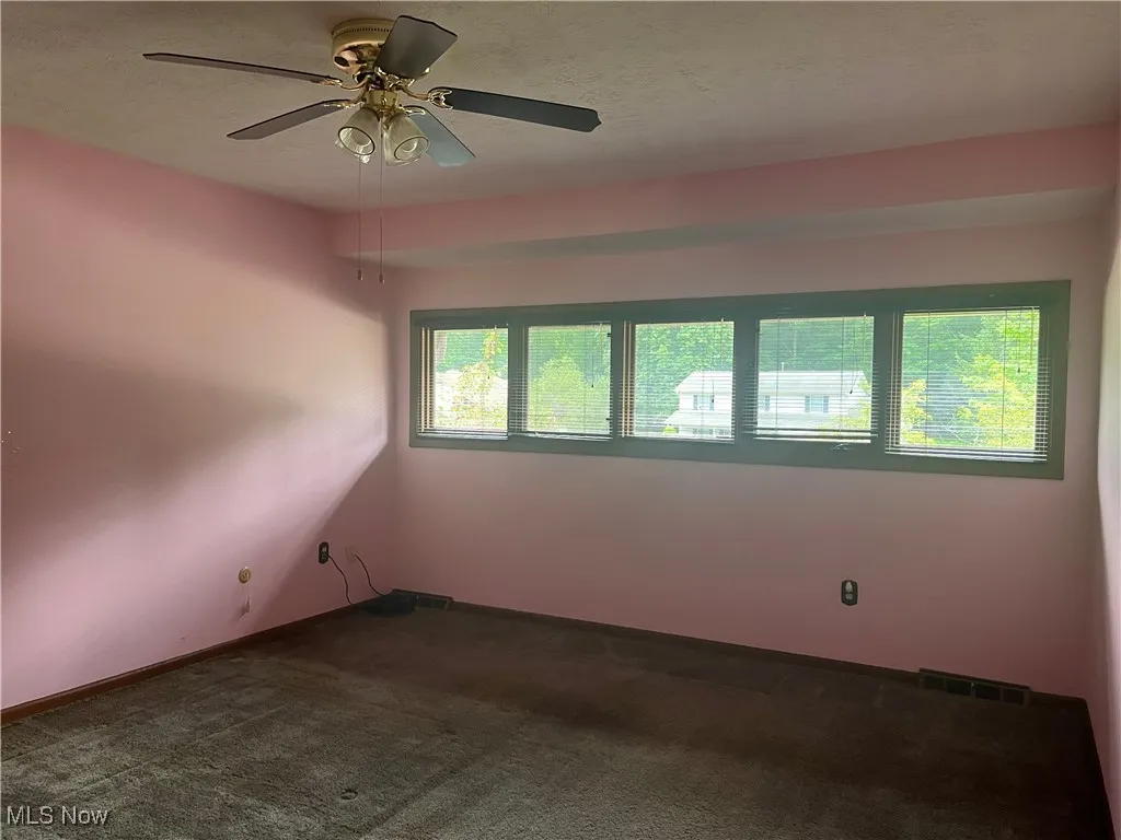 Bedroom #2 features a ceiling fan light and a wall of windows.