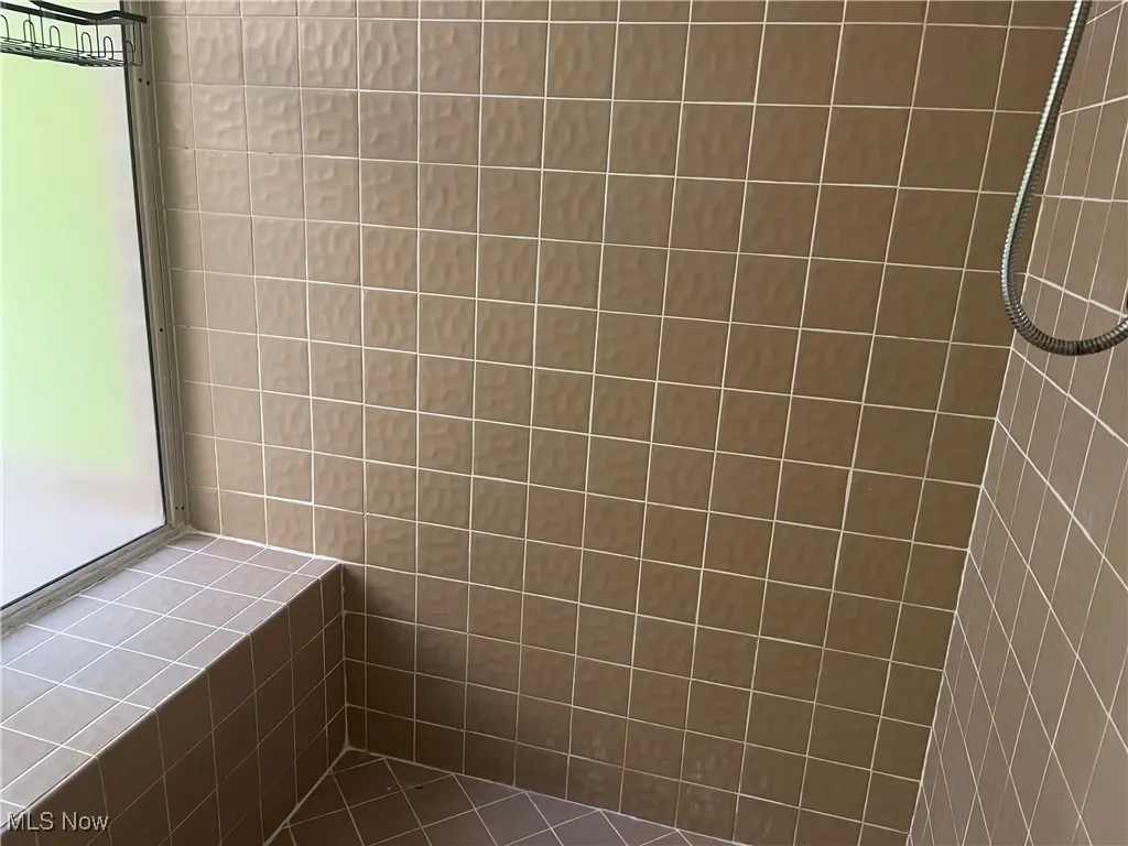 Tiled Shower has a place to sit