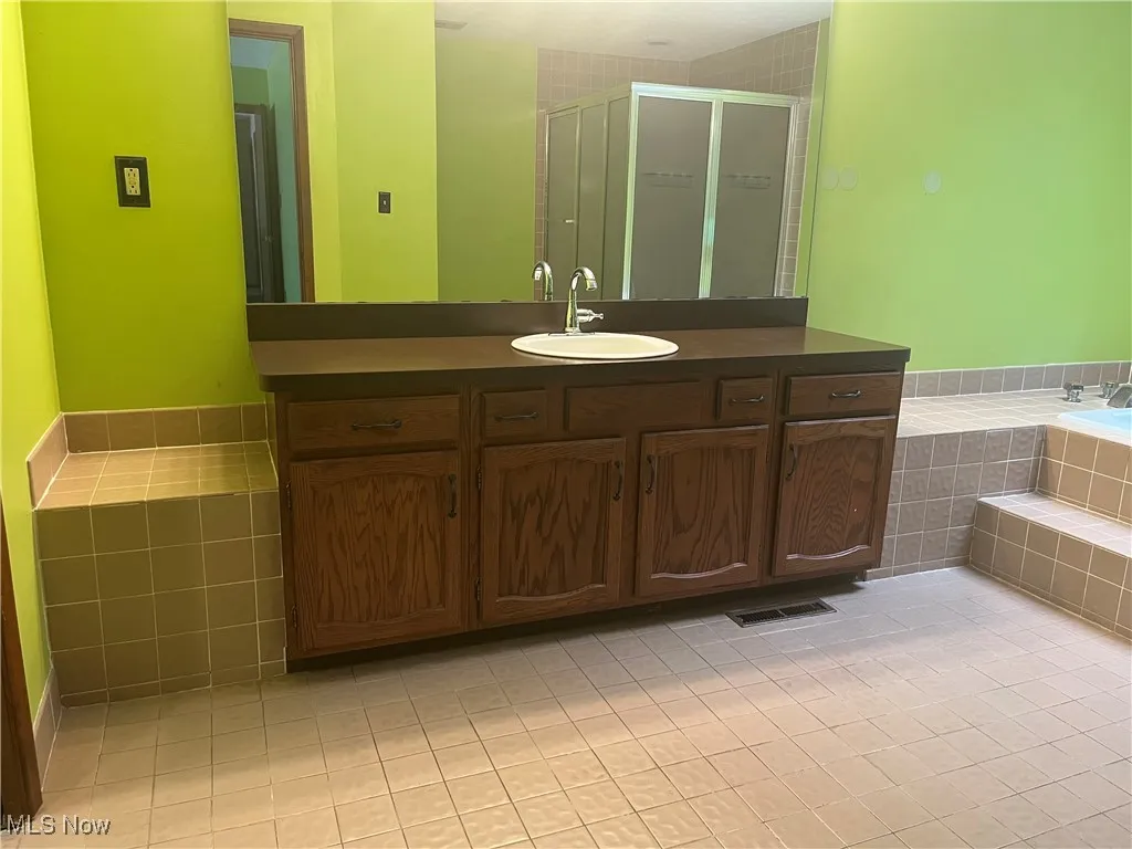 Full bath with vanity, tile patterned flooring, a shower stall, and a bath