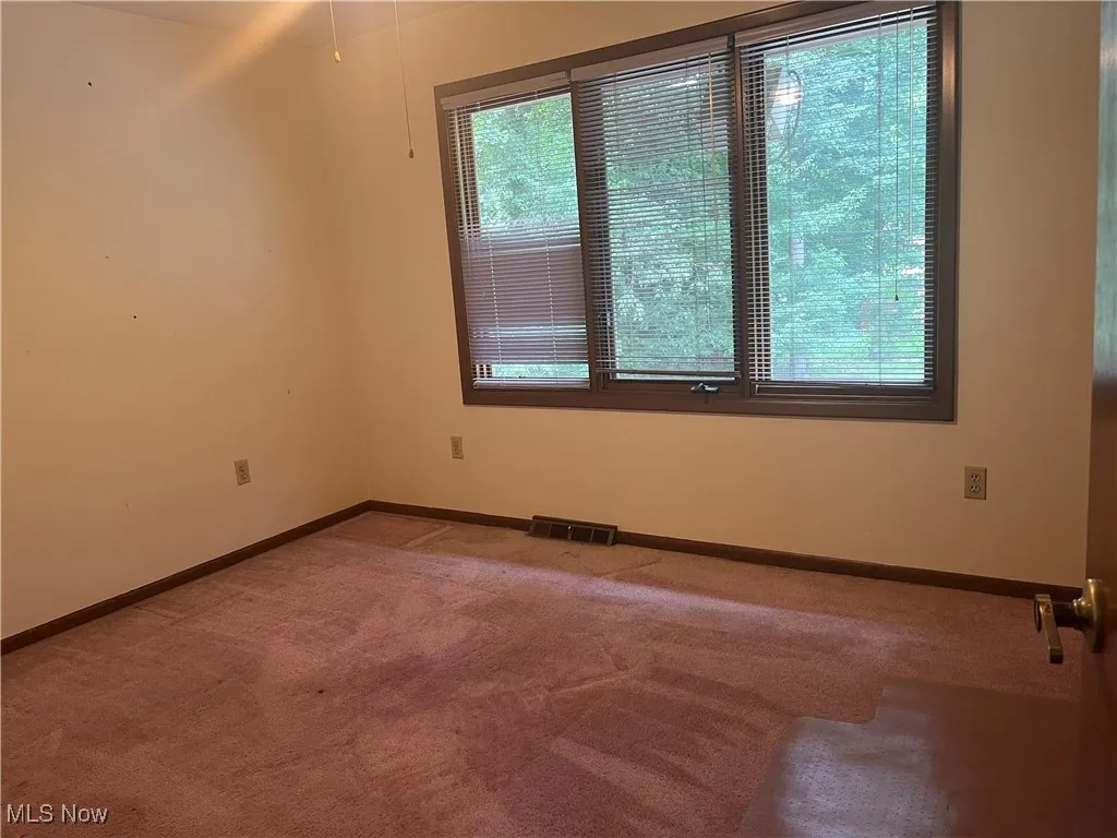 Bedroom #4 is carpeted and large windows that bring in natural light.