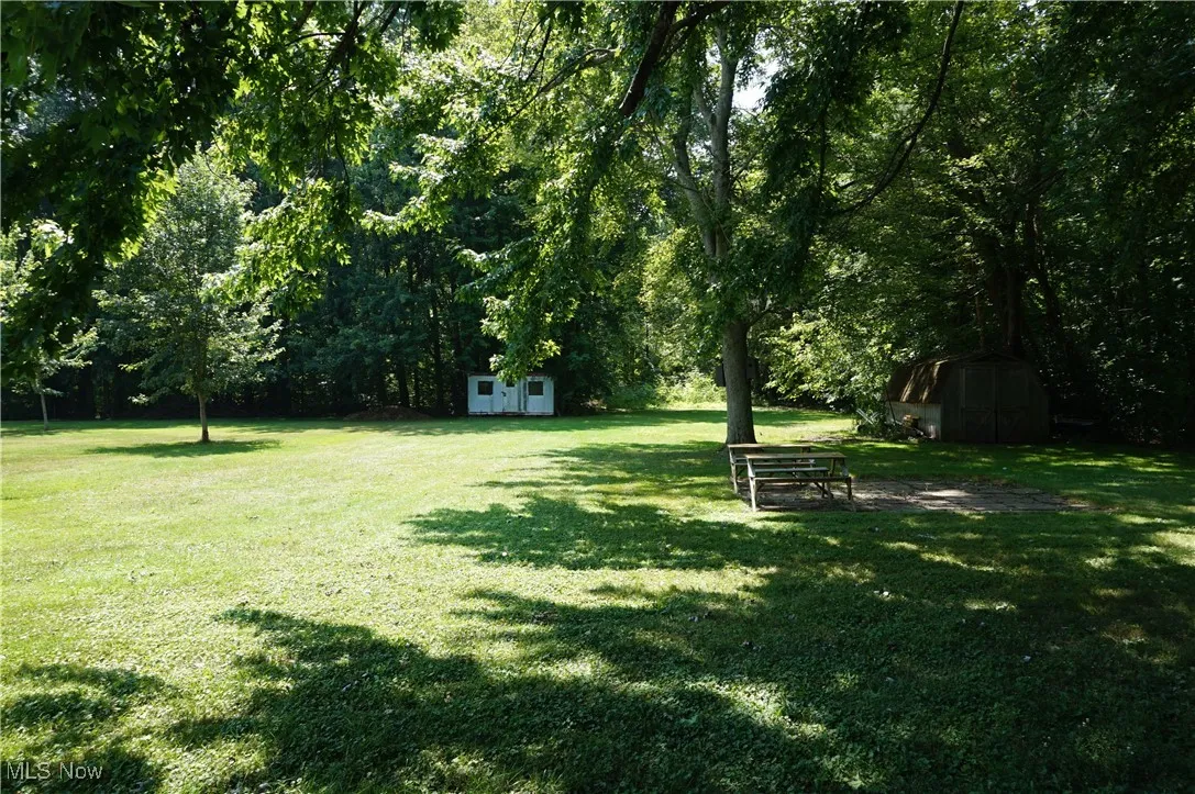 Back yard with wooded rear, garden shed, white shed does not stay.
