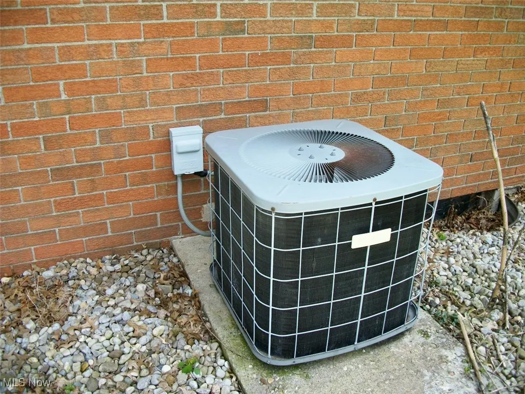 Exterior view of a central AC unit and brick siding