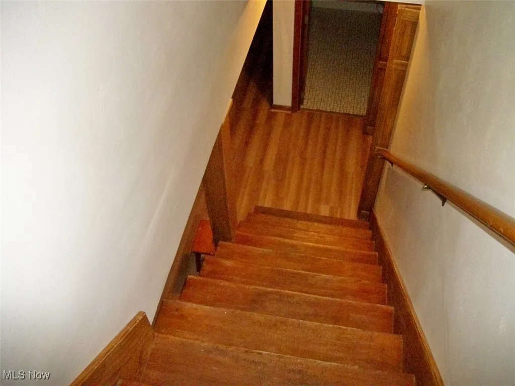 Stairway featuring wood finished floors