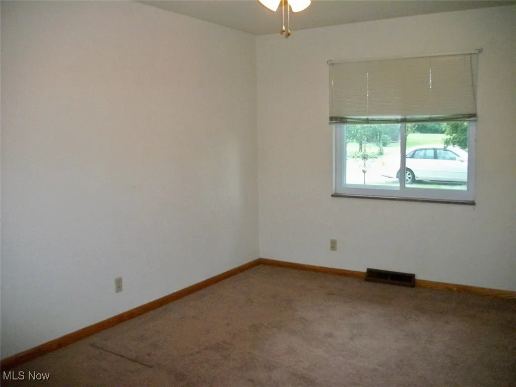 Carpeted  room featuring baseboards