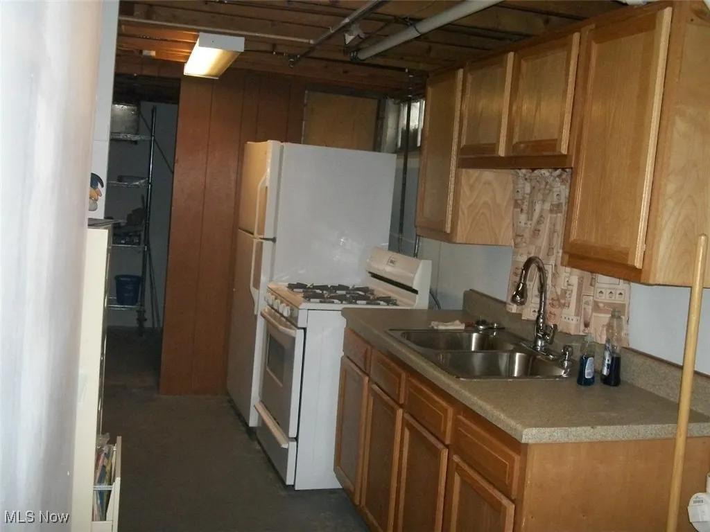 Summer Kitchen with white range with gas cooktop, brown cabinets, and light countertops