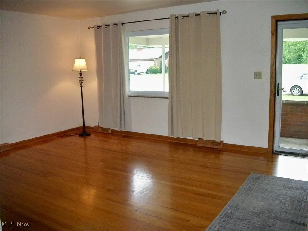  featuring baseboards and wood finished floors with double pane window.