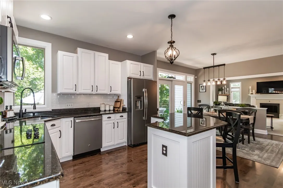 Modern Kitchen with granite countertops, and white backsplash