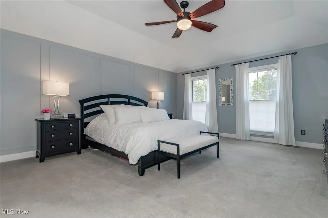 Massive Master Bedroom with light colored carpet, lofted ceiling, and ceiling fan