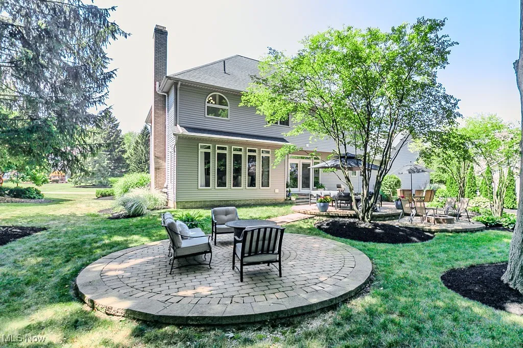 Back of property with multiple brick paver patio areas
