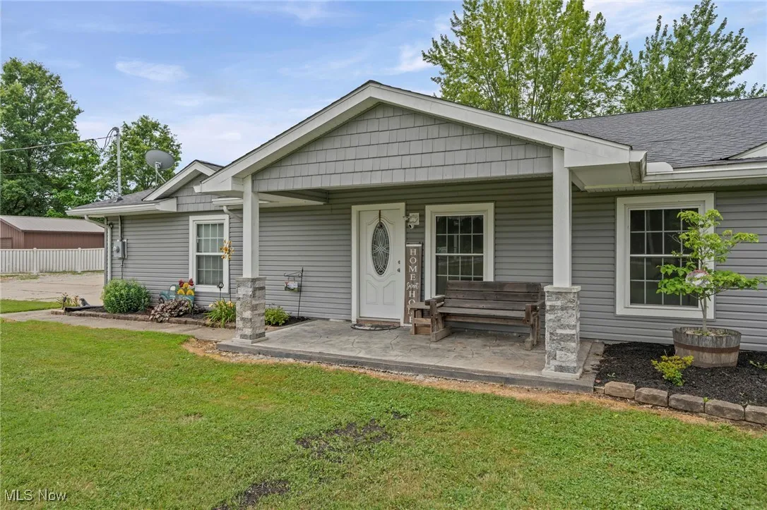 View of front of house featuring a front lawn, a porch, and roof with shingles