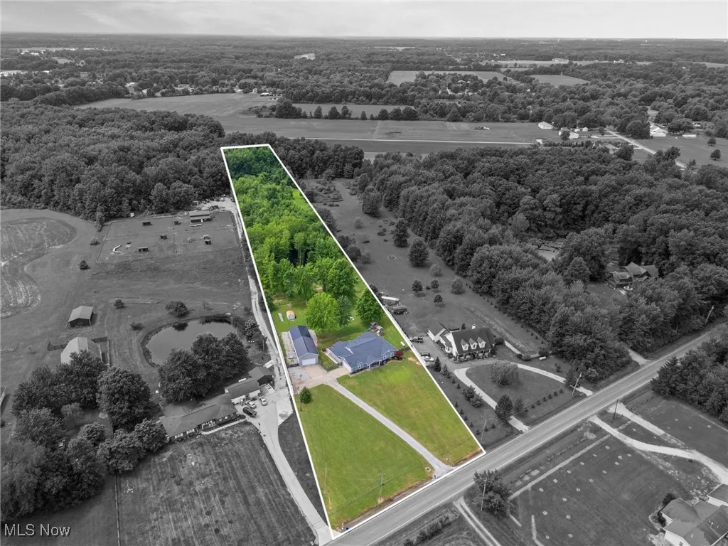 Aerial view of property and surrounding area with property boundaries highlighted and a heavily wooded area