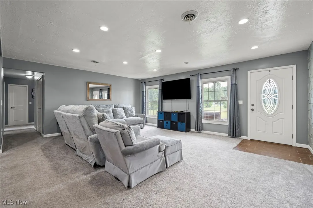 Living room featuring carpet, a textured ceiling, and recessed lighting