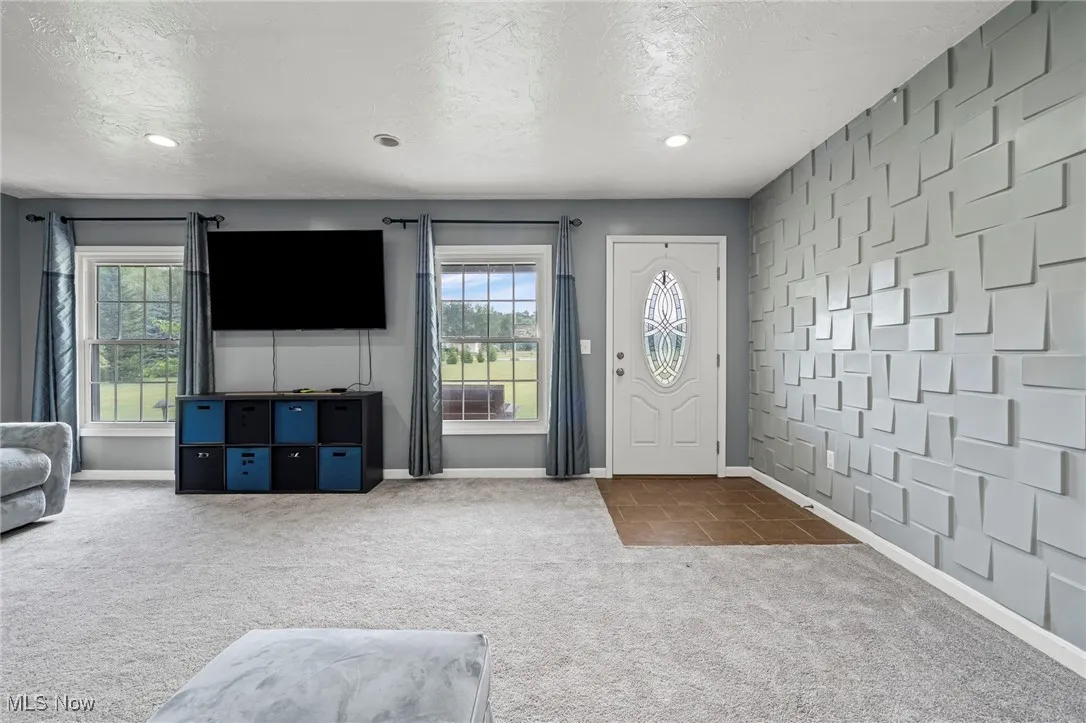 Carpeted entrance with a textured ceiling and recessed lighting