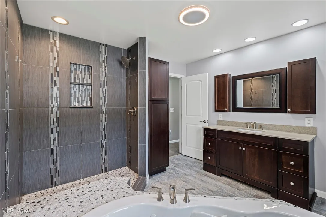 Master Bathroom with a shower stall, vanity, a jetted tub, and recessed lighting