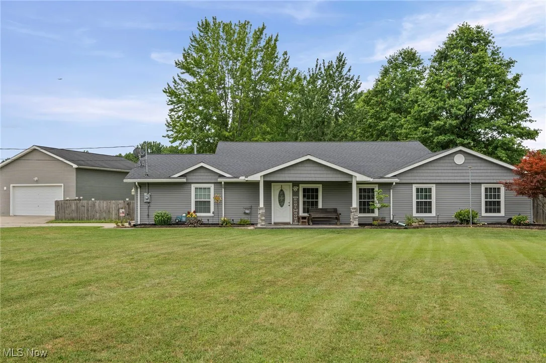 Single story home featuring a large front yard and a garage