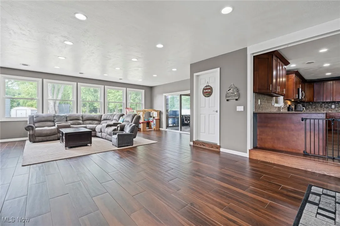Family room with dark wood-style floors and recessed lighting