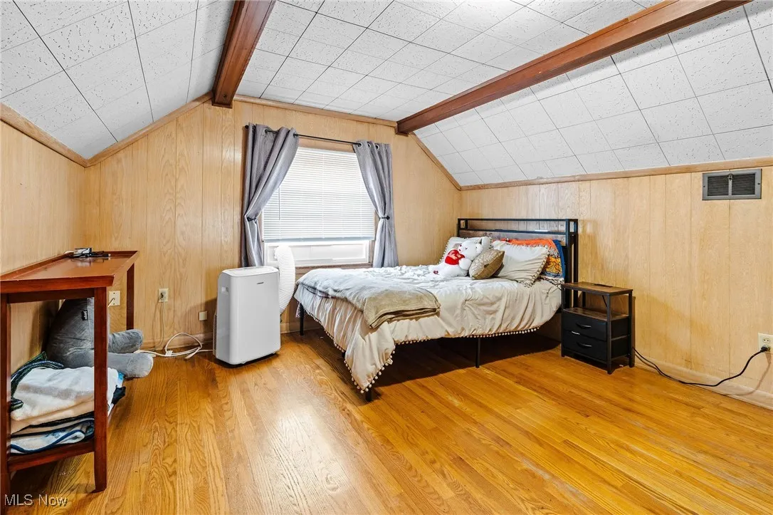 Large 2nd floor Primary Bedroom Suite with hardwood floors, vaulted beam ceiling, and paneled walls