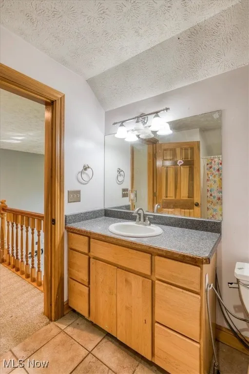 Full bath featuring vanity, a textured ceiling, and tile patterned flooring