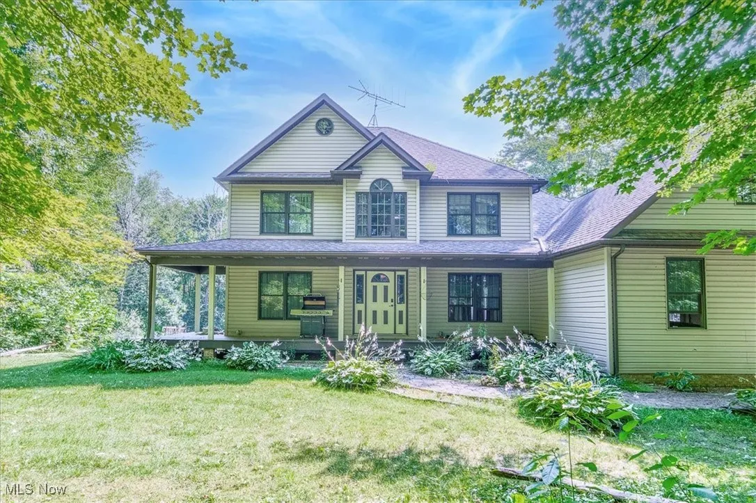 View of front of home with covered porch and a front lawn