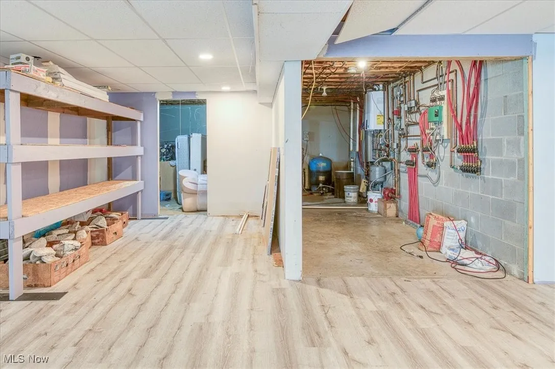 Unfinished basement featuring wood finished floors and a water pressure tank
