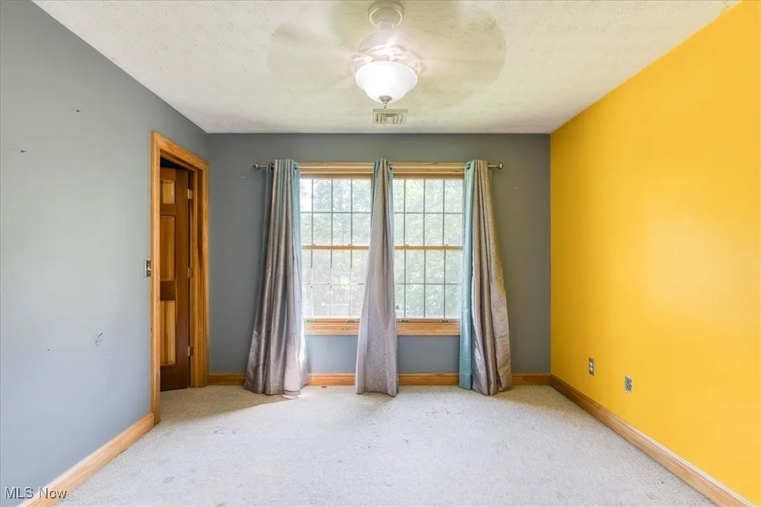 Carpeted spare room featuring baseboards and a textured ceiling