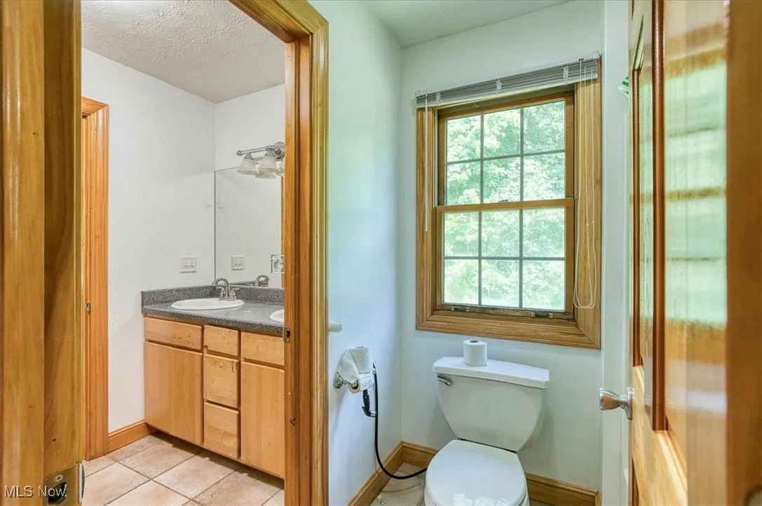 Bathroom featuring vanity, tile patterned floors, and a textured ceiling
