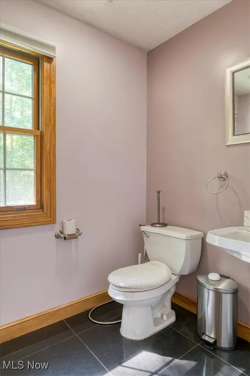 Half bathroom featuring toilet and a textured ceiling