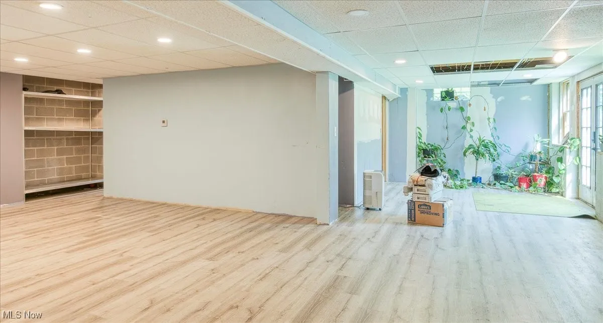 Unfurnished room featuring a drop ceiling and wood finished floors