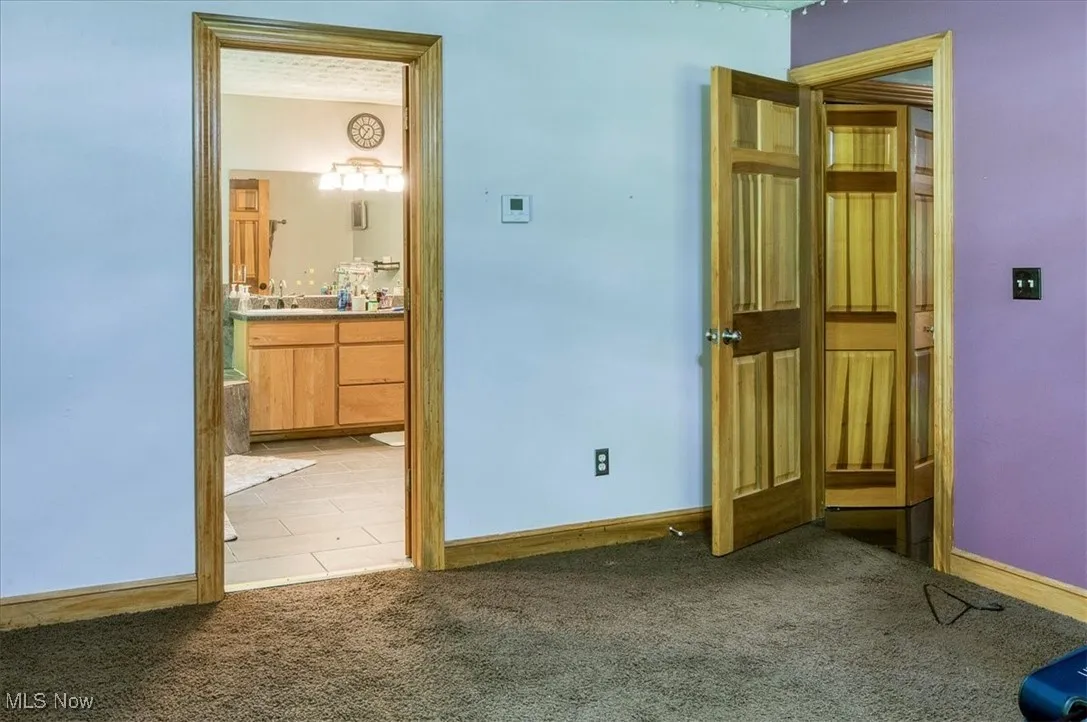 Unfurnished bedroom featuring carpet floors and connected bathroom
